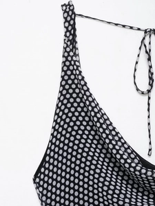 Detail of polka dot dress featuring thin straps and back lace-up knot closure