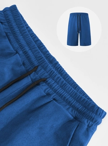 Detail of men's blue sports shorts showing elastic waistband, drawstring and knit texture