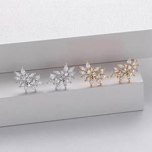 Detailed view of S925 silver and gold snowflake stud earrings with sparkling crystals