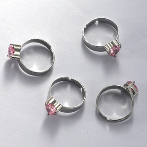 Detailed overhead view of four adjustable silver rings featuring pink heart-shaped zircons
