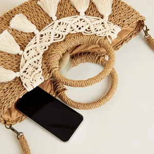 Detalle de bolsa de paja tejida con borlas bohemias y forro interior espacioso