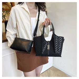 Detail of black printed tote bag set with a silver clasp and a small crossbody pouch