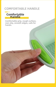 Detail showing the comfortable green non-slip handle and ergonomic grip of the baking pan