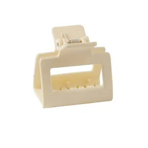Detail view of cream square hair claw clip with matte finish and durable metal spring