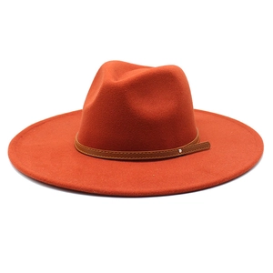 Detailed view of wide-brimmed orange wool fedora with a stitched leather band and buckle