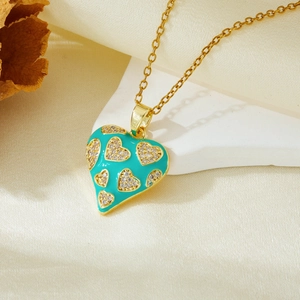 Detailed view of a green enamel heart pendant with golden rhinestones on a gold chain