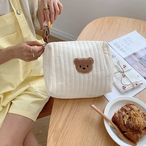 Quilted cotton baby stroller bag with bear embroidery on a wooden table setup