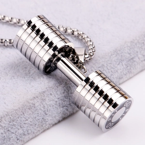 Macro view of silver stainless steel dumbbell pendant with GO FIT engraving on a grey velvet mat