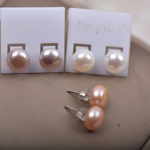 Macro shot of white, pink and purple freshwater pearl stud earrings with silicone backs