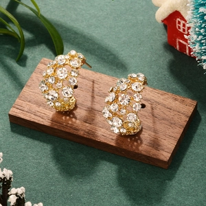 Close-up of gold semi-hoop earrings encrusted with sparkling white cubic zirconia stones