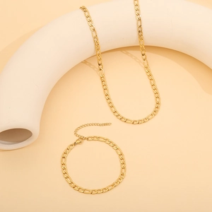 Close-up of golden Figaro chain necklace and bracelet set with lobster clasp detail