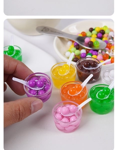 Detailopname van miniatuur dessertkommodellen met kleurrijke parels en kleine lepels