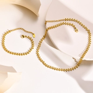 Close-up of gold heart-shaped link necklace and bracelet set with K18 engraved tag