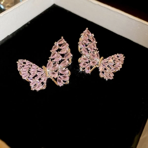 Close-up of pink zircon butterfly stud earrings on a black velvet jewelry box background