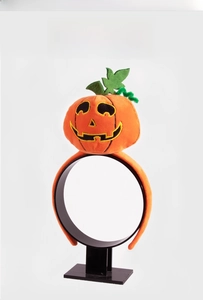 Detail of plush orange pumpkin headband with green leaf accent for Halloween party props