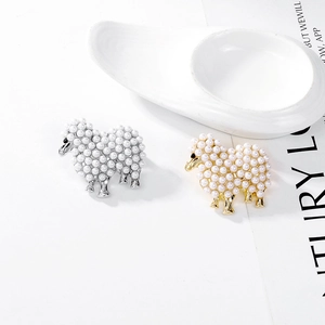 Broche mouton créative avec perles blanches en finitions or et argent sur fond blanc