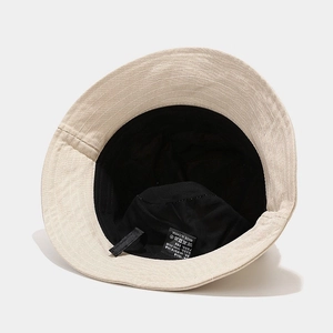 Détail d'un bob en coton lavé beige avec doublure intérieure noire et coutures solides