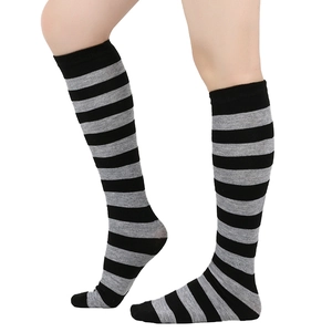 Detail of knee-high striped socks in black and grey, showing knit texture on model