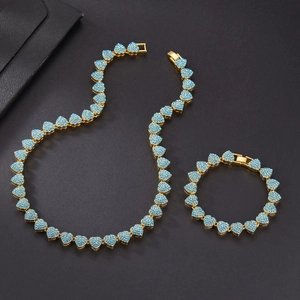 Detail of gold Cuban chain set featuring 10mm blue rhinestone encrusted heart links