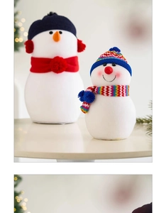 Détail de deux bonhommes de neige en peluche avec écharpes rouges et bleues sur table