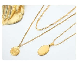 Close-up of gold-plated layered necklaces with Elizabeth II coin and oval pendants