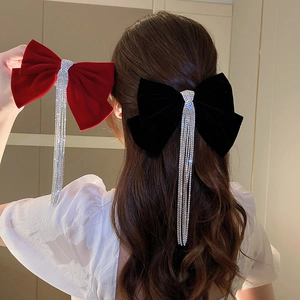 Detail of velvet bow hair clips with sparkling rhinestone tassels in red and black