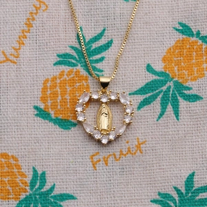 Golden necklace with cubic zirconia heart pendant featuring religious relief and box chain