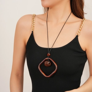 Close-up of brown resin square pendant with sphere bead on long wax cord necklace