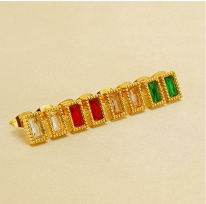 Détail macro de boucles d'oreilles rectangles dorées serties de zircons en 4 couleurs