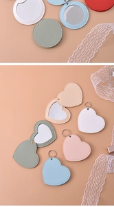Flat lay of colorful heart and round PU leather compact mirrors with lace decor