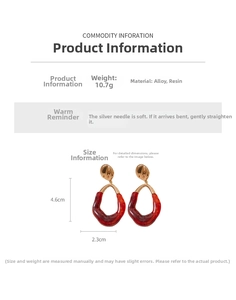 Detail showing asymmetrical resin earrings with red amber texture and gold wavy metal parts