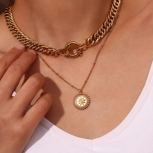 Close-up of a layered golden chunky chain necklace set with a sun pendant for women