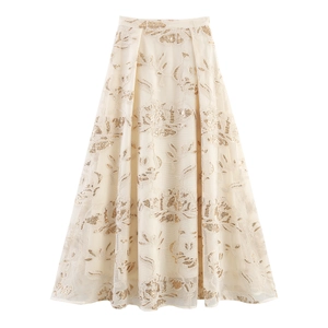 Detail of mesh maxi skirt with intricate gold sequin floral embroidery and elegant pleats
