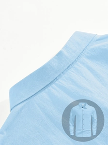 Detail of light blue linen shirt featuring a lapel collar and textured fabric surface