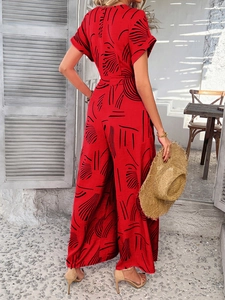 Back view of a red floral wide-leg jumpsuit with waist belt and short sleeves