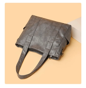 Top view of grey PU leather tote bag with reinforced straps and zipper detail