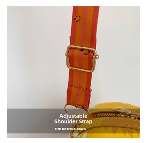 Close-up of adjustable striped shoulder strap with pumpkin prints and gold hardware