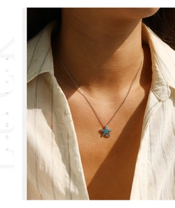 Detail of starfish pendant necklace with turquoise stone inlay on elegant model