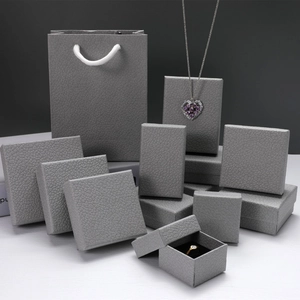 Detailed view of grey lychee textured jewelry boxes and matching paper gift bag