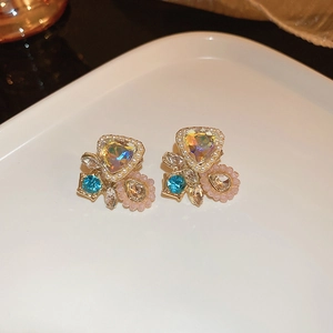 Gros plan de boucles d'oreilles florales avec gemmes colorées et détails de perles