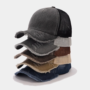 Nahaufnahme gestapelter Mesh-Basecaps im Vintage-Look mit verschiedenen Farben und Textur