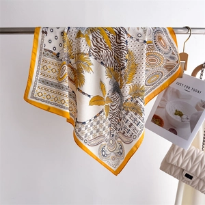 Detail of silk square scarf featuring leopard print and tropical leaves on a gold base