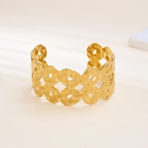 Detailed view of wide gold open cuff bracelet with hammered texture and hollow circles