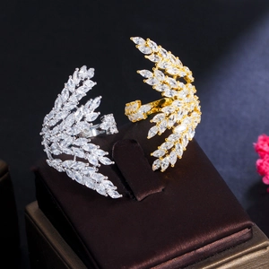 Macro detail of gold and silver angel wing rings with pavé zircon stones on velvet