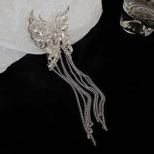 Detailed close-up of a silver butterfly hair claw with liquid metal texture and tassels