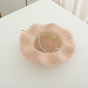 Vue détaillée de l'intérieur d'un chapeau de paille rose avec cordon réglable et bord dentelle