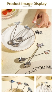 Detail of stainless steel cat-themed coffee spoons with colorful painted ceramic handles