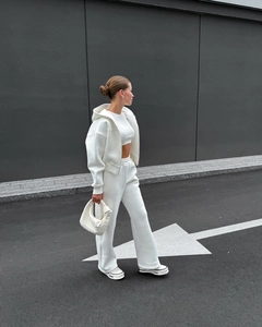 Détail d'un ensemble sweat à capuche blanc avec pantalon large et sac à main tressé