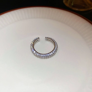 Detailed close-up of a silver-plated double-row zircon twisted open ring on white ceramic