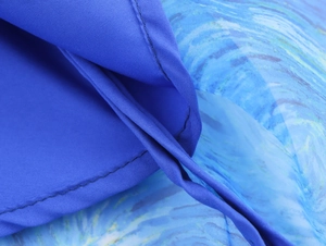 Dettaglio dell'orlo in organza a balze con stampa sfumata blu a tema cielo stellato